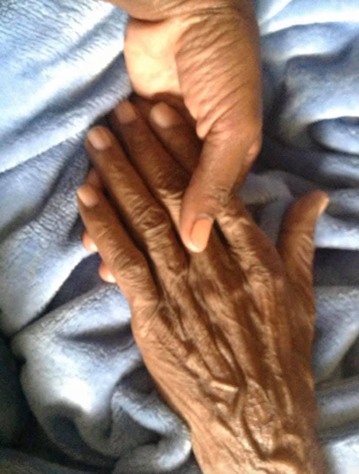 Hands held together in a quiet moment of family care